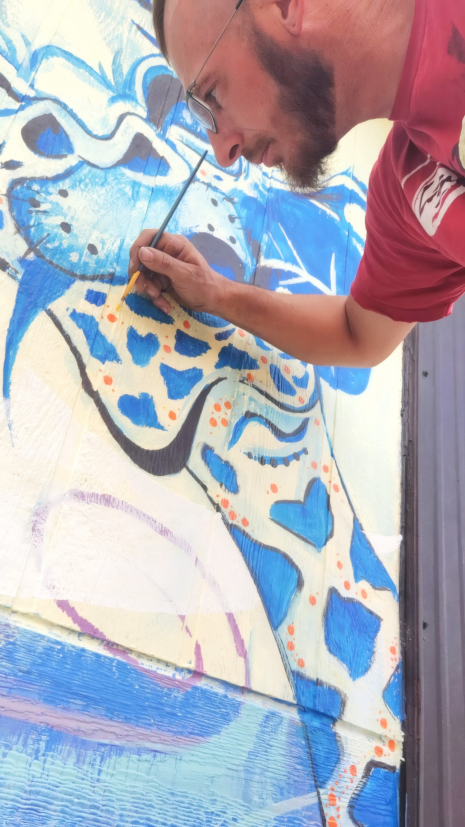 Artist painting a mural up close
